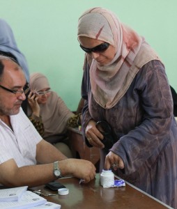 בוחרת בקלפי בקהיר טובלת את אצבעה בדיו, כדי לחתום על טופס הבחירה שלה (Flickr/Nehal ElSherif)