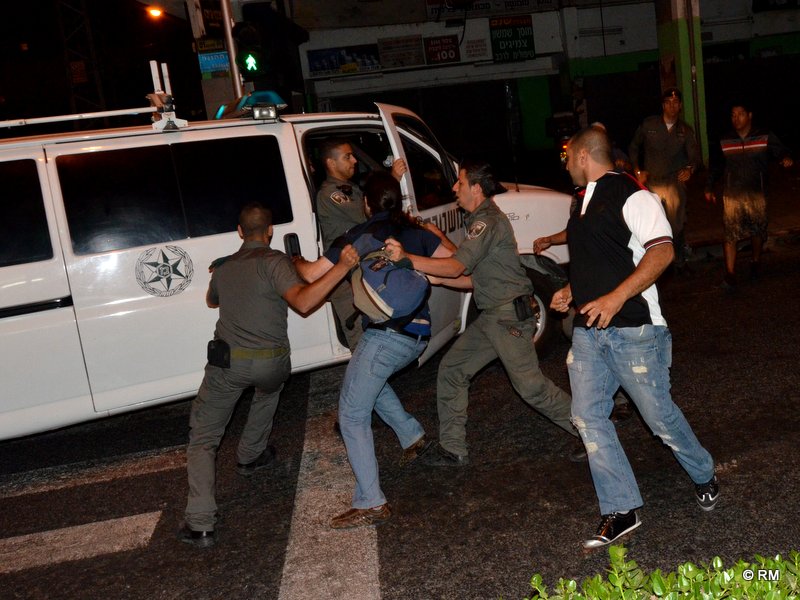 שוטרים מפנים אדם שהותקף בידי המפגינים (צילום: רפי מיכאלי)