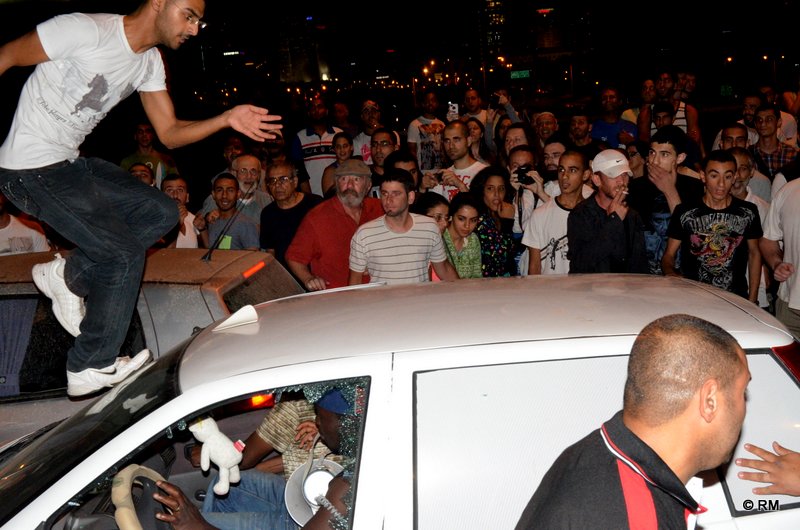 מפגינים מתנפלים על מכונית עם מהגרים ומנפצים שמשות לאחר ההפגנה בשוק תקווה (צילום: רפי מיכאלי)