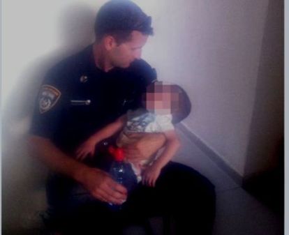 הילד בזרועות השוטר הולצוקי בתחנת המשטרה בערד