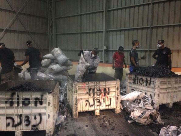 סורקים את שקי הפחם בתוך מחסני הבידוק במסוף ניצנה (צילום: משטרת ש"י)