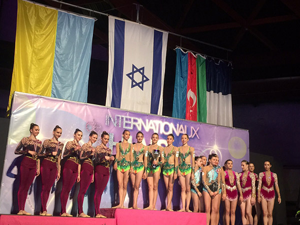 מתעמלות נבחרת ישראל על הפודיום; דגל ישראל מאחוריהן. צילום: איגוד ההתעמלות