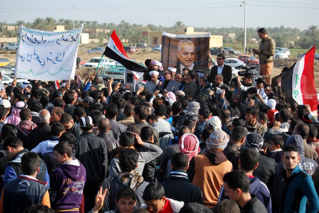 מפגינים סונים ליד העיר רמאדי שבמחוז אל-אנבאר מוחים על מדיניות ממשלת אל-מאלכּי ומניפים את תמונתו של סגן הנשיא הגולה, הסוני טארק אל-האשמי (צילום: AFP PHOTO/STR)