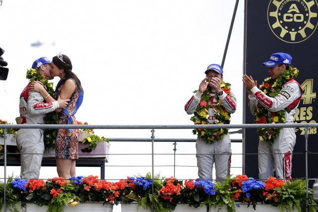 נשיקות על הפודיום. קריסטנסן מתנשק עם מיס לה מאן 2013 (במקביל למירוץ מתקיימת תחרות מלכת יופי) בזמן שחבריו לצוות והקהל מפרגנים. 24h of Le Mans. צילום: AUDI AG