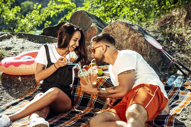 young-couple-having-picnic-riverside-sunny-day